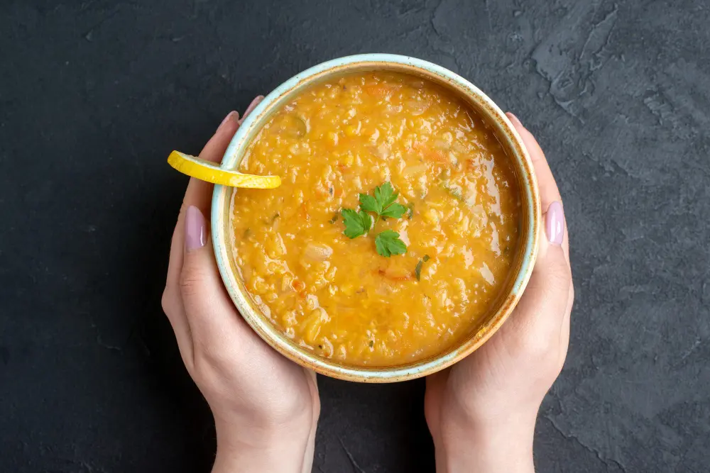 Indian heart healthy meal with moong dal khichdi, barley, spinach, tomato, carrot, and walnuts